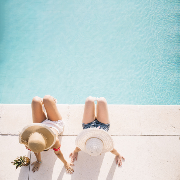 vue-de-dessus-des-filles-en-face-de-la-piscine_23-2147814780